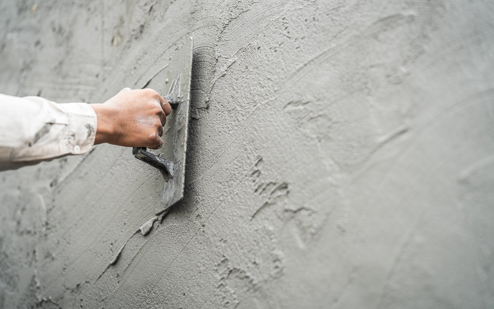 Worker applying cement plaster to an exterior wall
