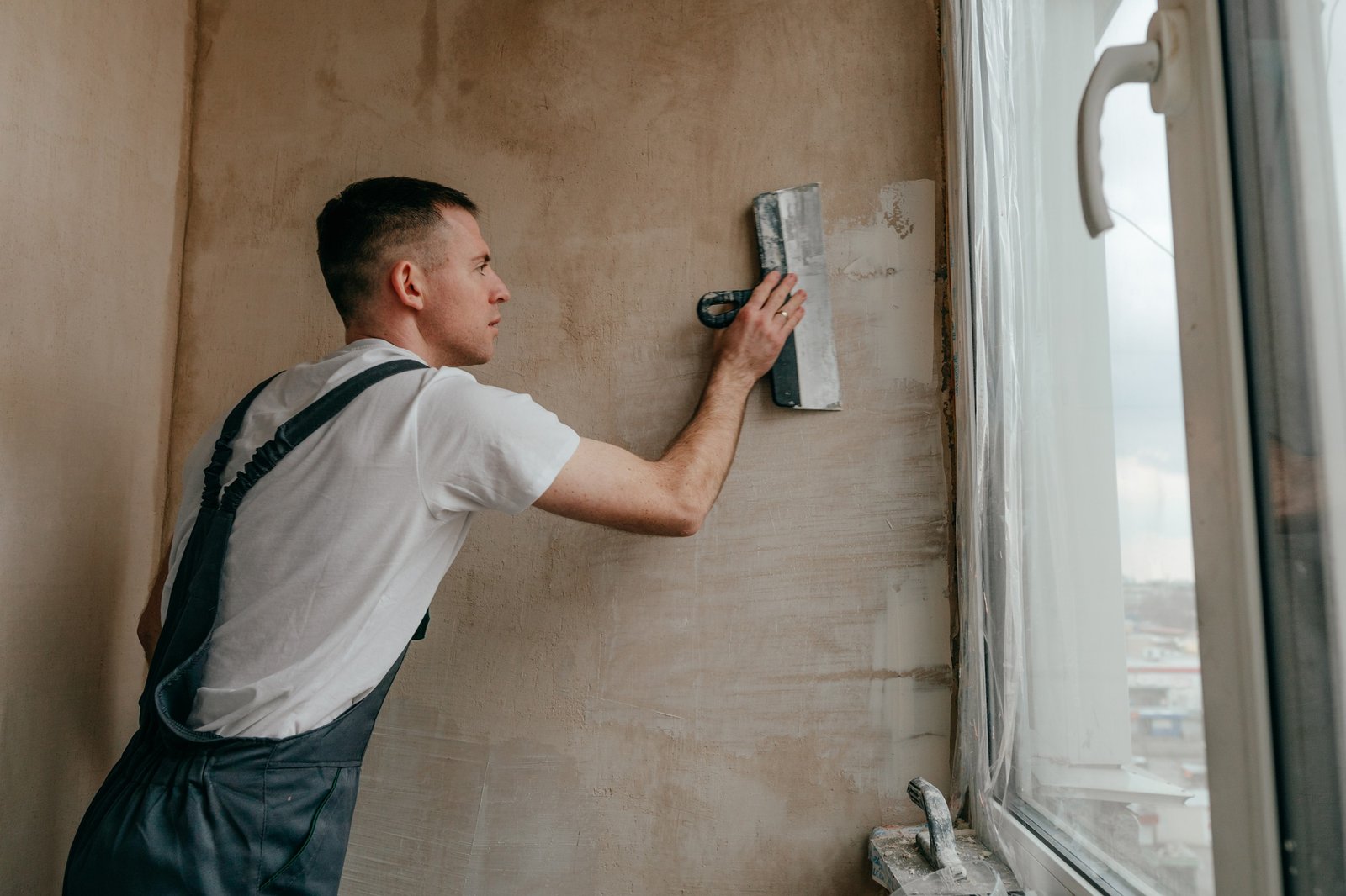 Worker applying wall putty on a wall surface