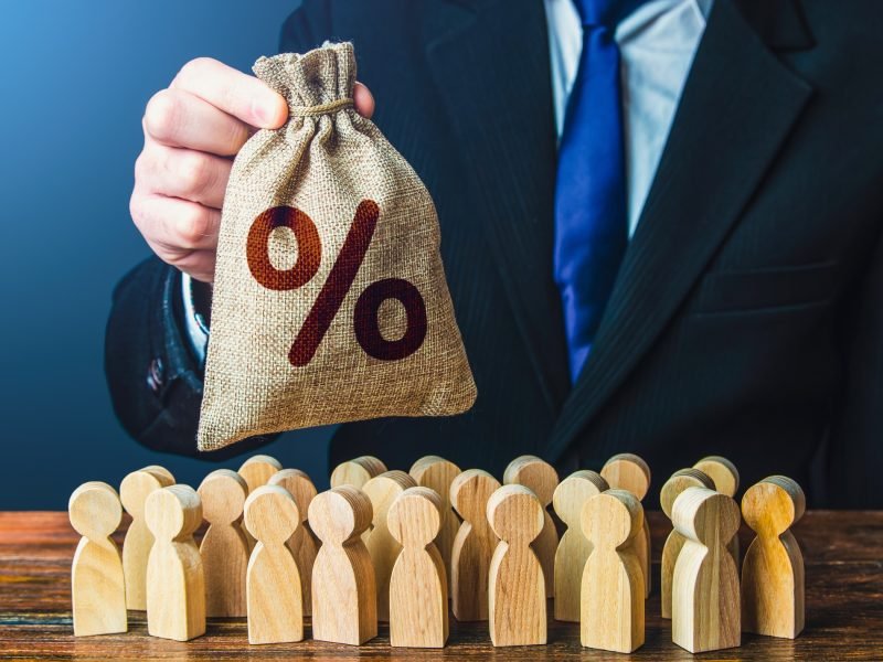 A businessman offers a bag with percent symbol to people.